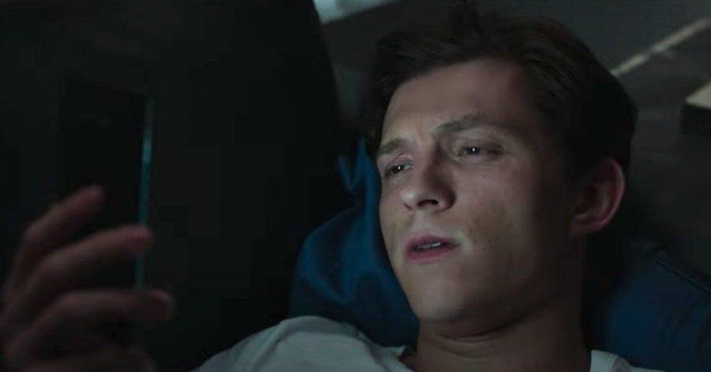 Tom Holland triste regardant sont portable dans Spiderman No Way Home