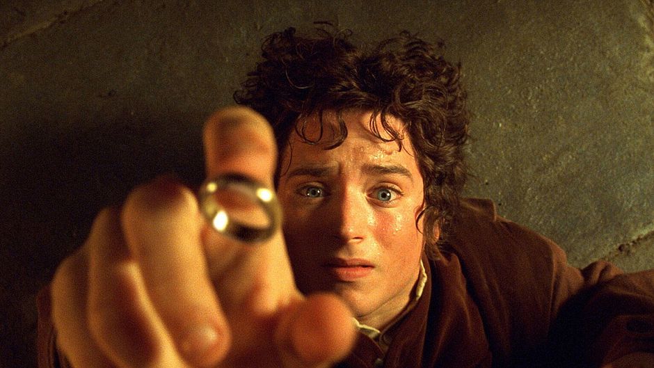 Elijah wood interprétant Frodo Sacquet s'apprete à passer l'anneau Unique dans le Seigneur des anneaxu de Peter Jackson